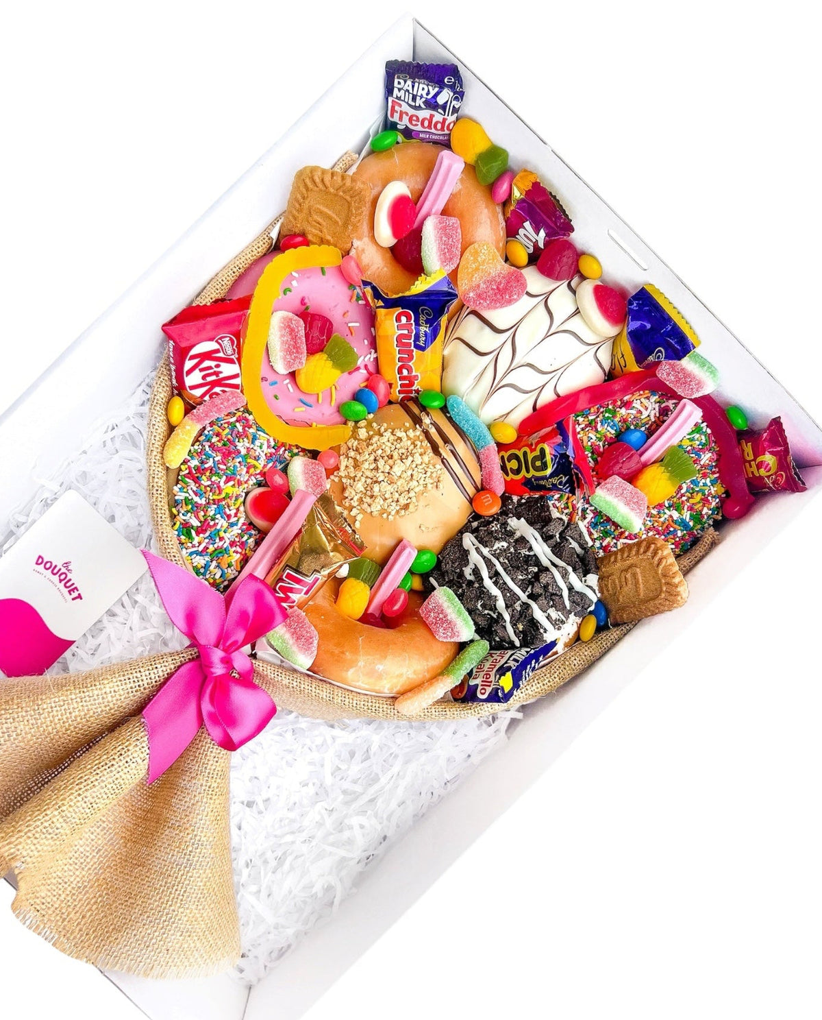 Angled view of a Medium Mixed Deluxe Donut Bouquet filled with donuts and colourful sweets.